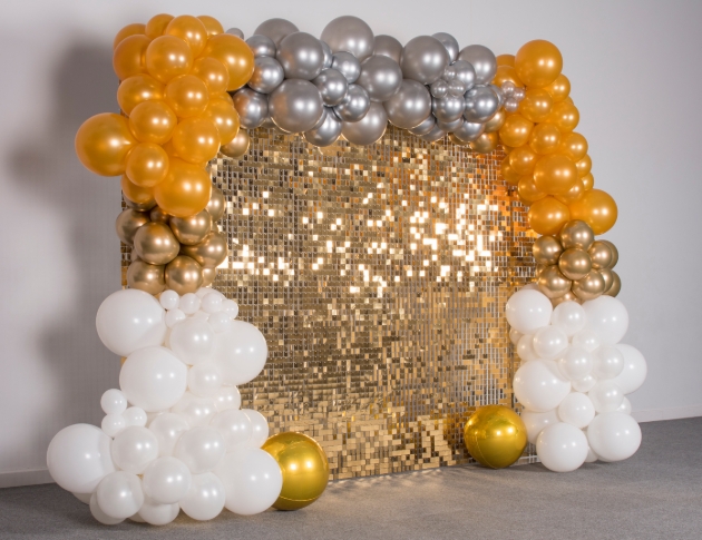 Gold sequin panel wall surrounded by balloons
