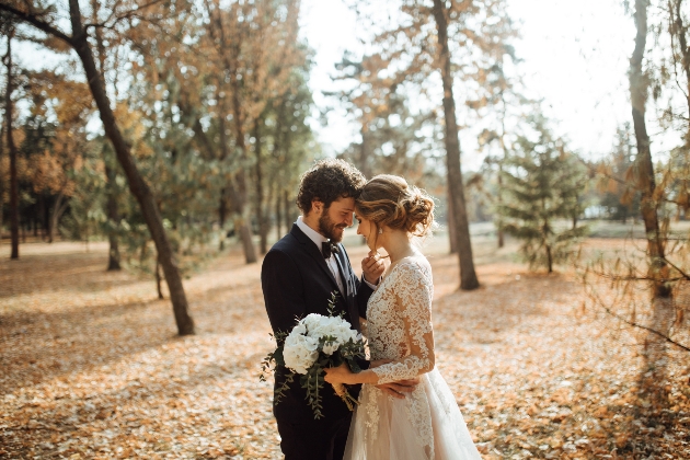 Couple pose at their idyllic outdoor wedding in woodland