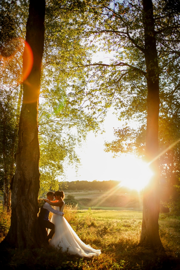 Bride and groom amongst trees at sunset at London Golf Club Kent