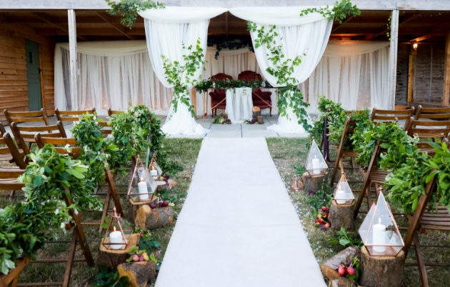 Outdoor wedding aisle decorated with foliage