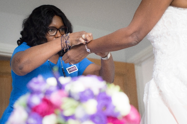Blessing helps bride Sandra with her bracelet