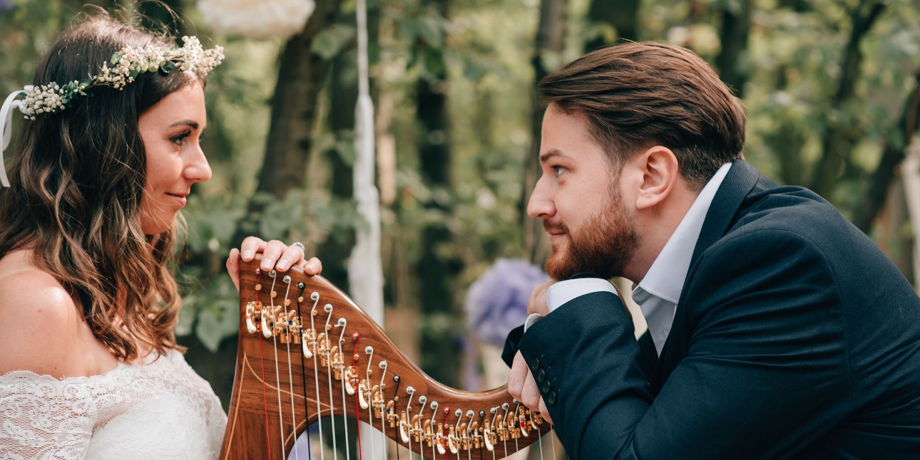 Bride and groom looking at each other over a harp