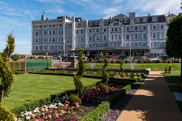 Hythe Imperial Hotel, grey imposing building with manicured gardens in front