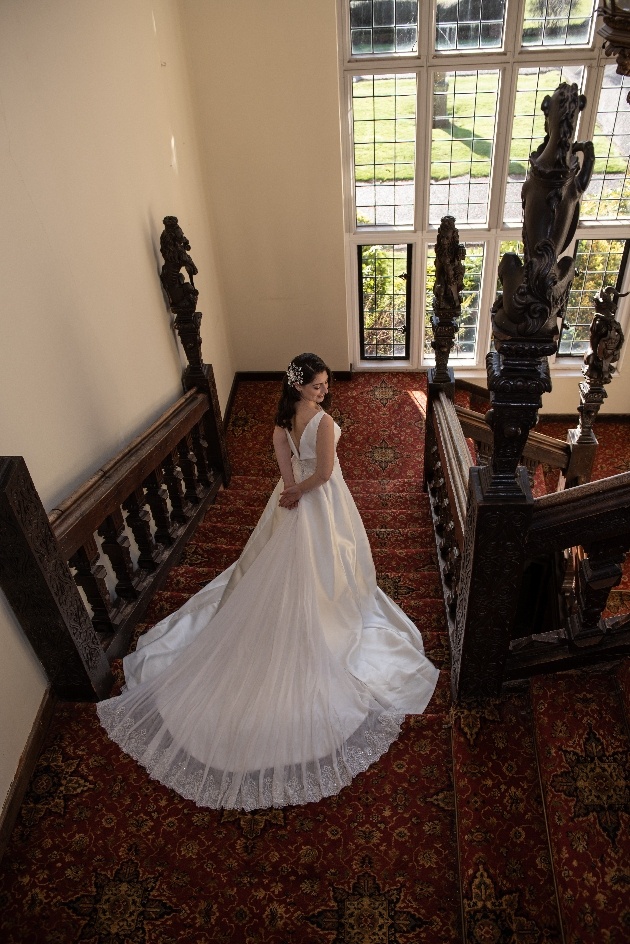 Overhead shot of bride at the top of the stairs at Broome Park