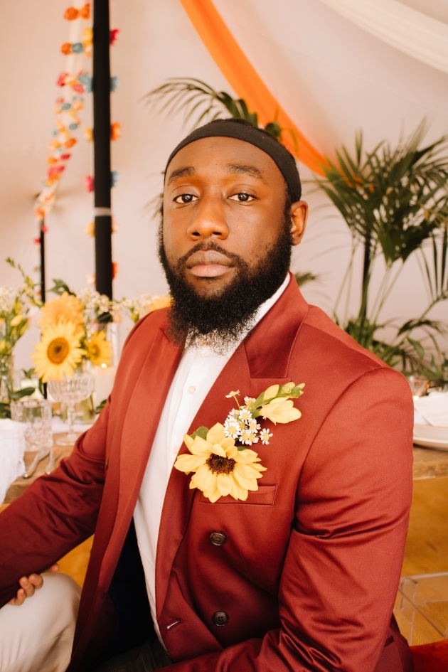 Groom dressed in vintage-style wedding suit with sunflower buttonhole