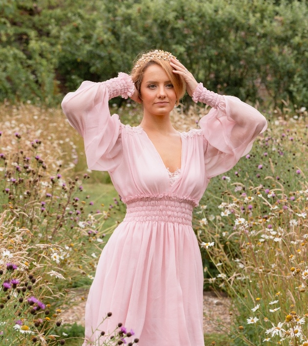 Bride in a meadow wearing beautiful pink wedding dress