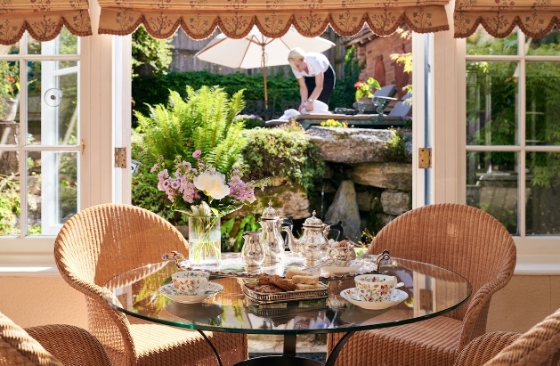 afternoon tea set at table doors open to gardens