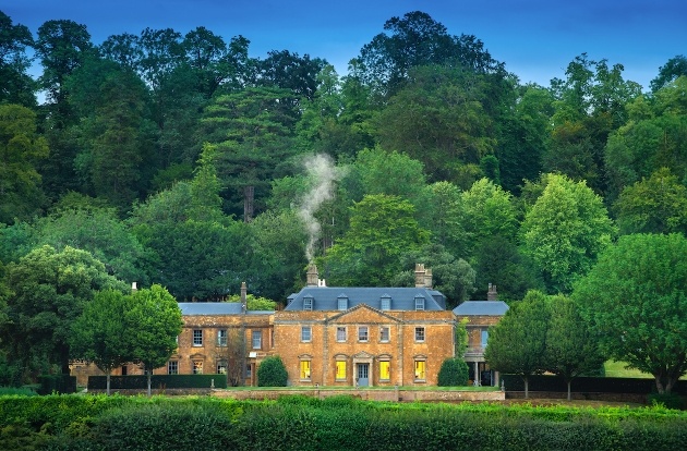 grand house surrounded by woodland 
