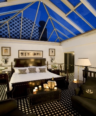 black and white styled room at night with candles in the room and glass roof