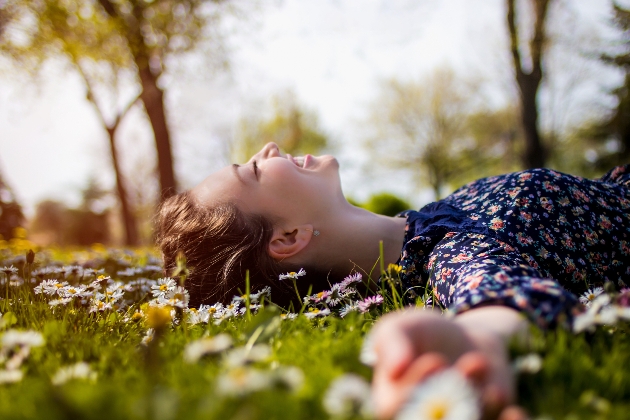 woman laying on ground in sunshine 