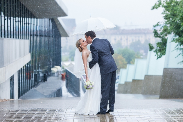 wedding couple under umbrella in rain 