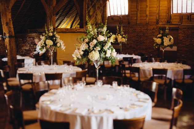 Wedding reception in rustic venue. Centrepieces in large martini glasses