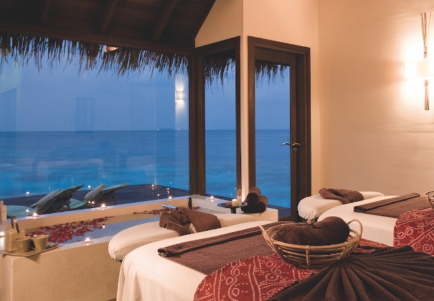 spa beds next to window looking out at ocean
