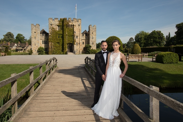 Bride and groom on bridge in front of Hever Castle