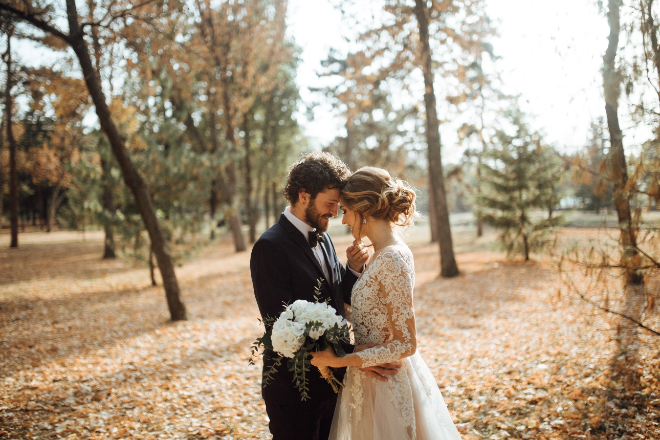 bride and groom standing in the woods