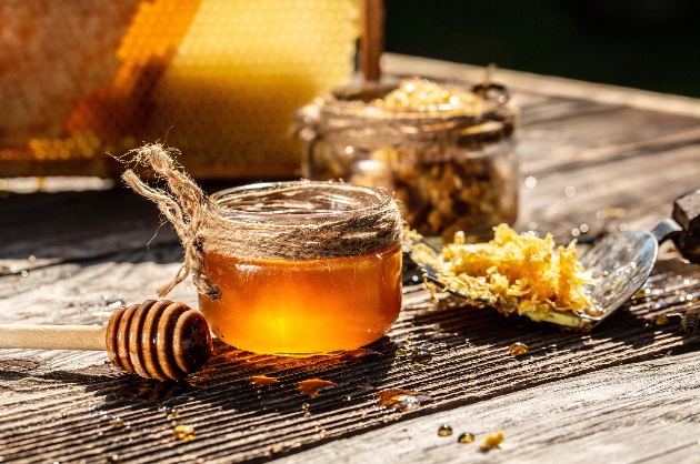 Honey bee and Honeycomb with honey dipper on wooden table. Beekeeping concept