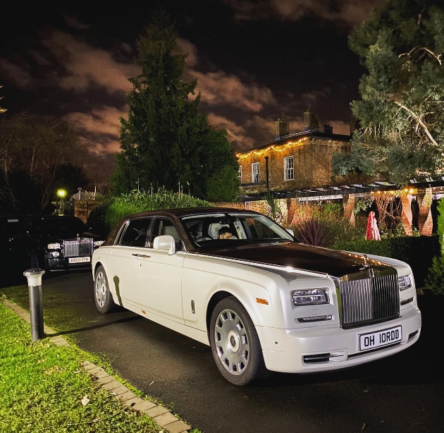 rolls royce black and white out side of house at night 