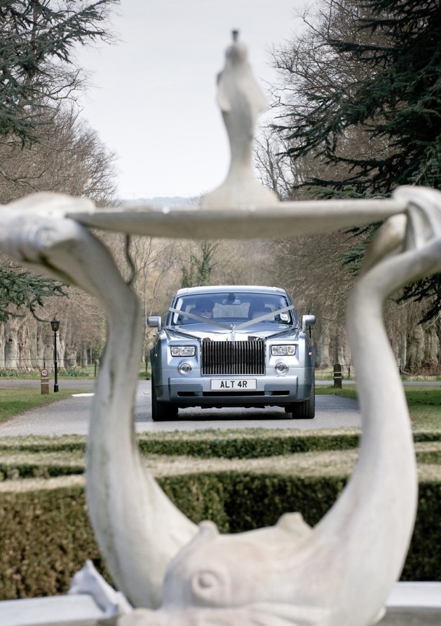 image of a silver car taken through a hole in a statue