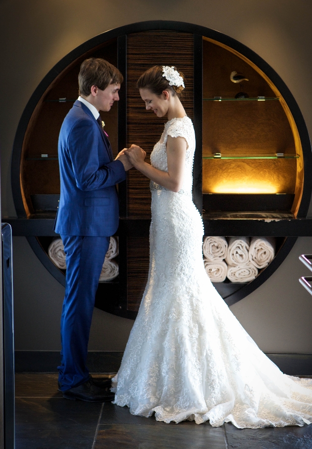 couple holding hands in front of a standout feature of the hotel