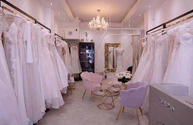 Wedding dress boutique lots of dresses hanging on rails, chandelier on ceiling
