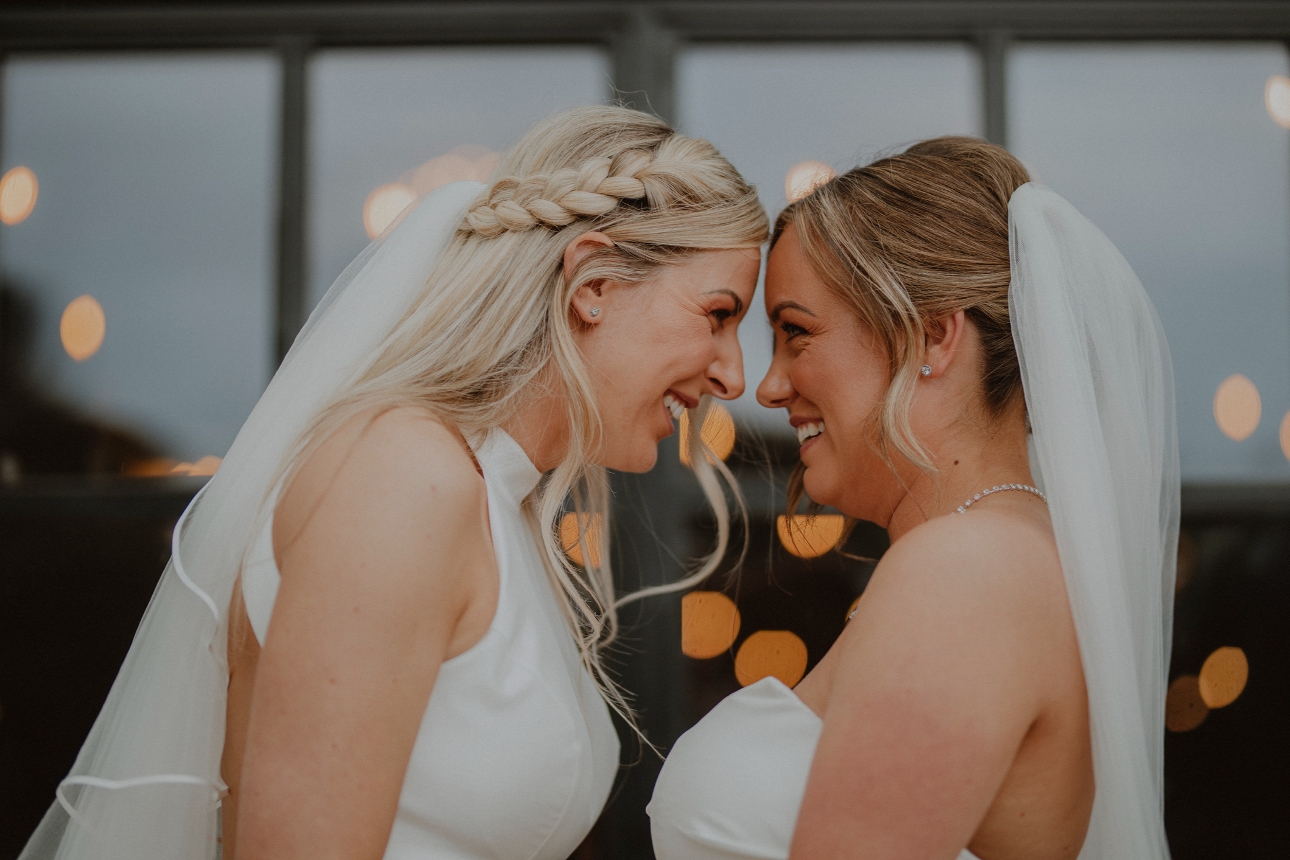 two brides touch foreheads and smile