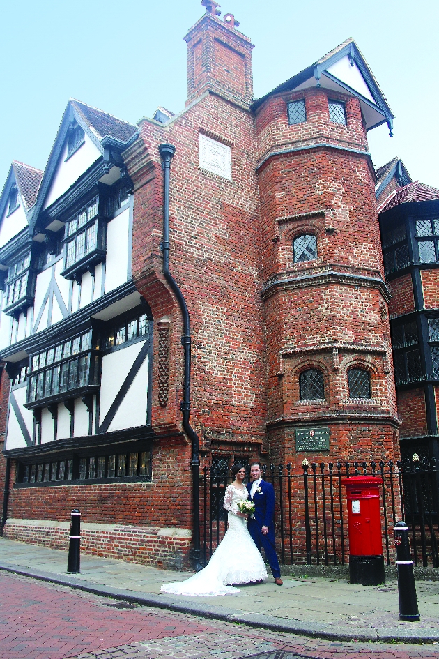 Bride and groom standing outside Eastgate House in Rochester