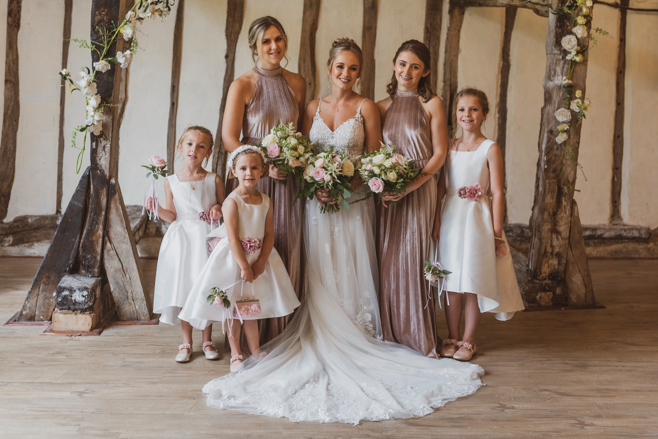 bride and her bridesmaids standing together in rustic room