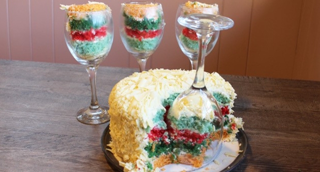 colourful layer cake with buttercream icing portioned with wine glasses