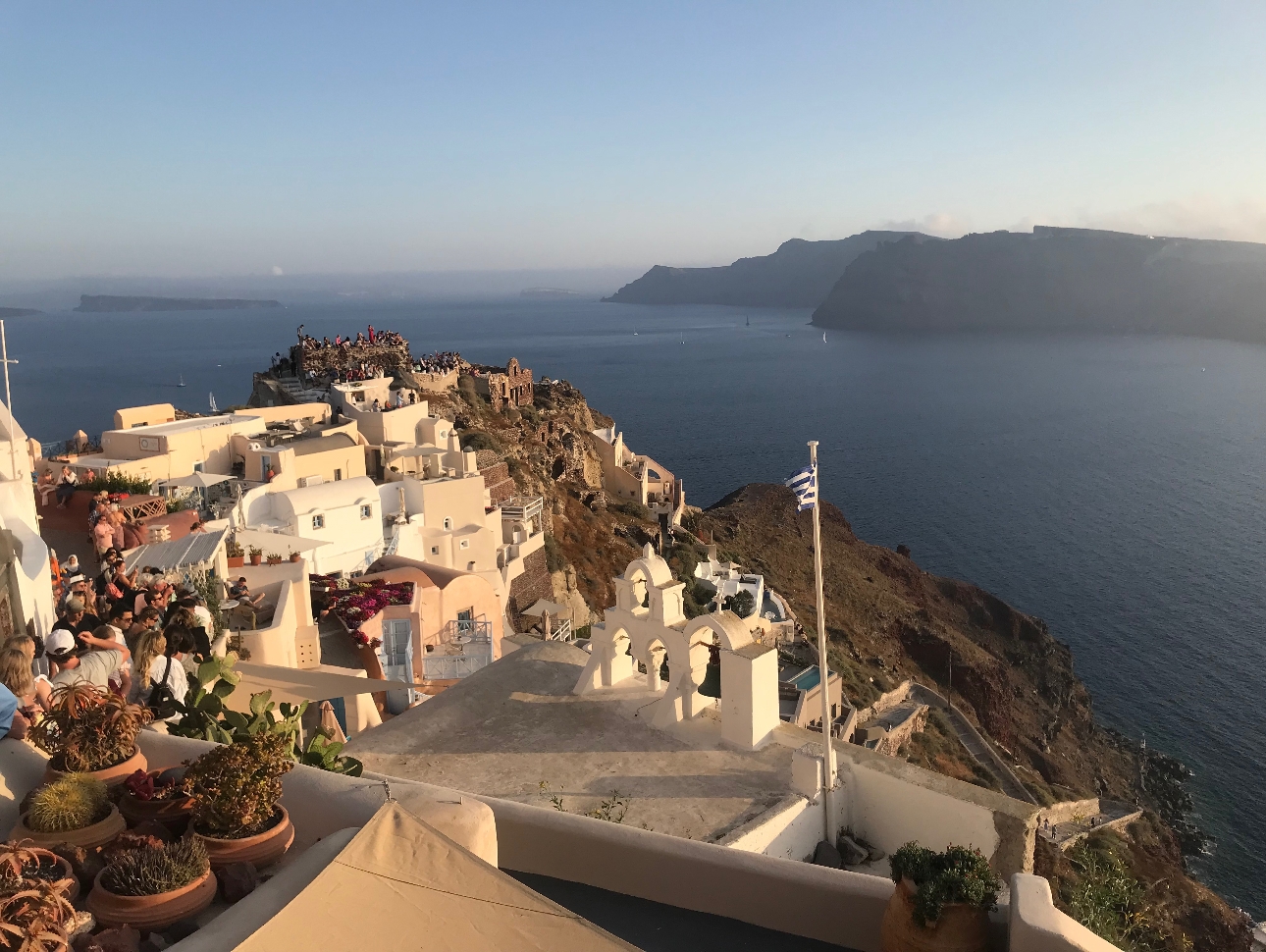 greek village on cliff edge views of the sea and sunset