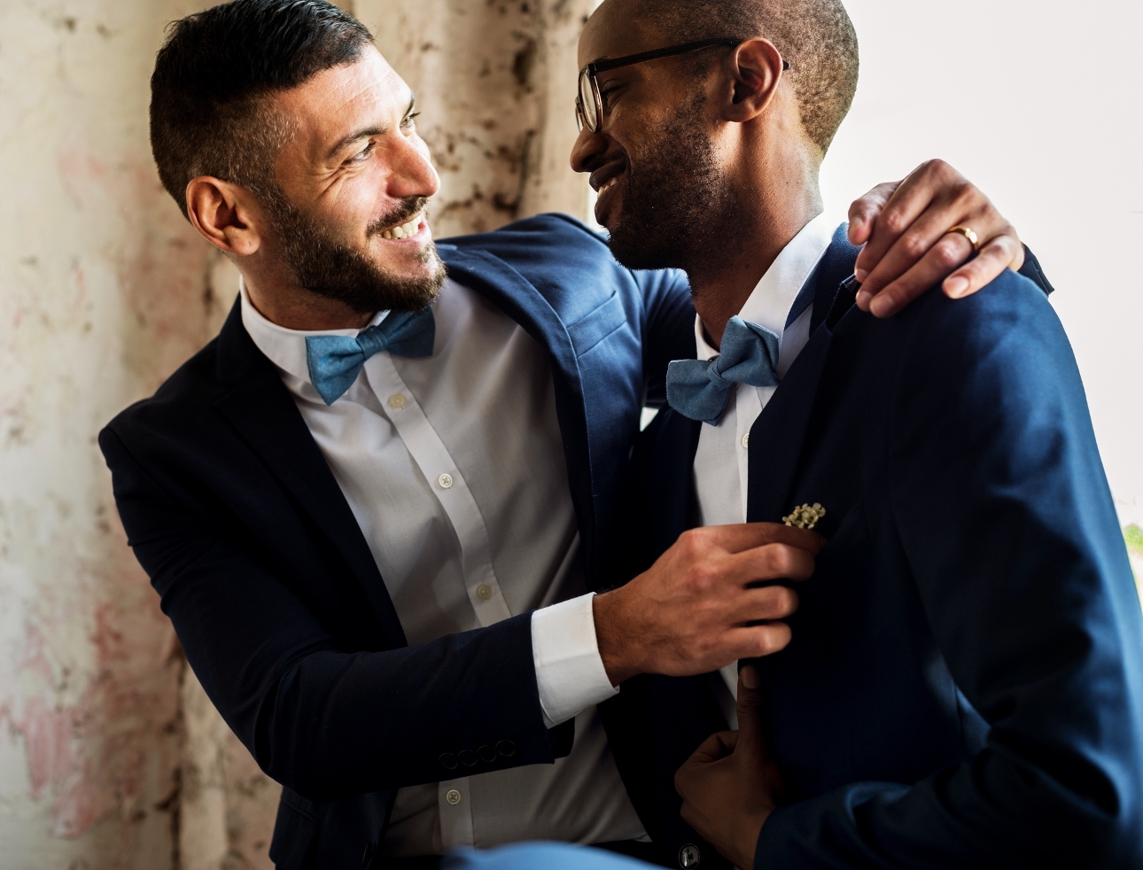 two grooms blue suit embracing 
