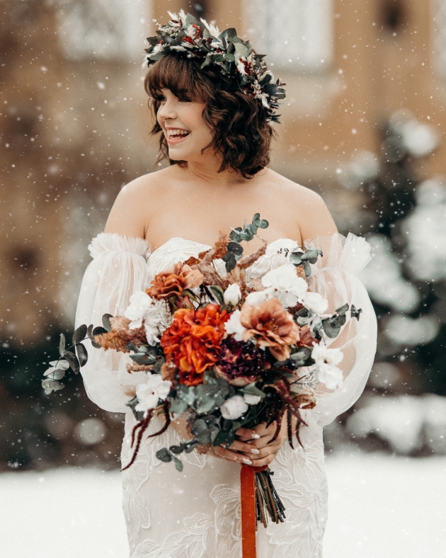 boho bride outside as snow falls