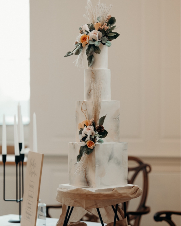 wedding cake with four tiers and peach and white sugar flower decoration 