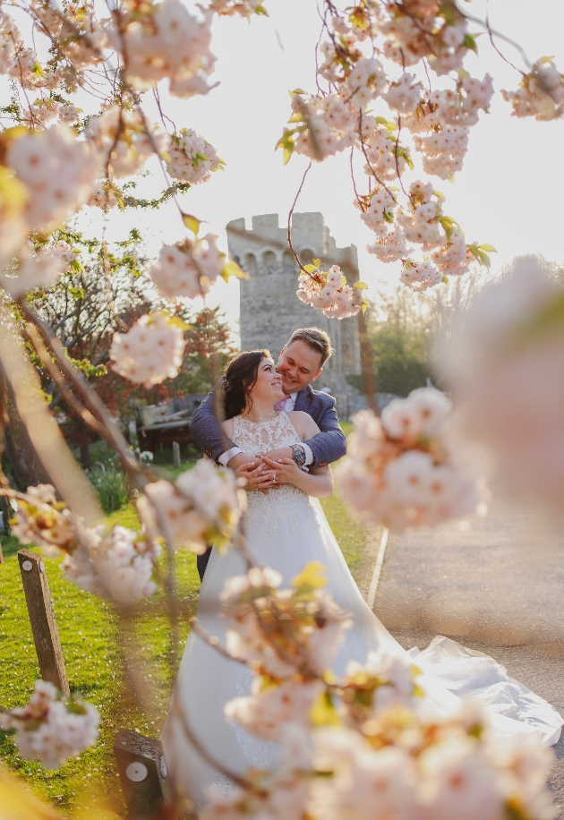 Bride and groom with spring blossoms in the foreground