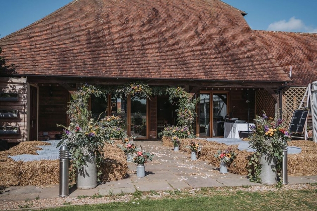 barn with haybales outside and large floral displays