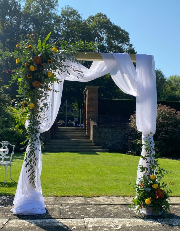 ceremony square arch covered in flowers and draping