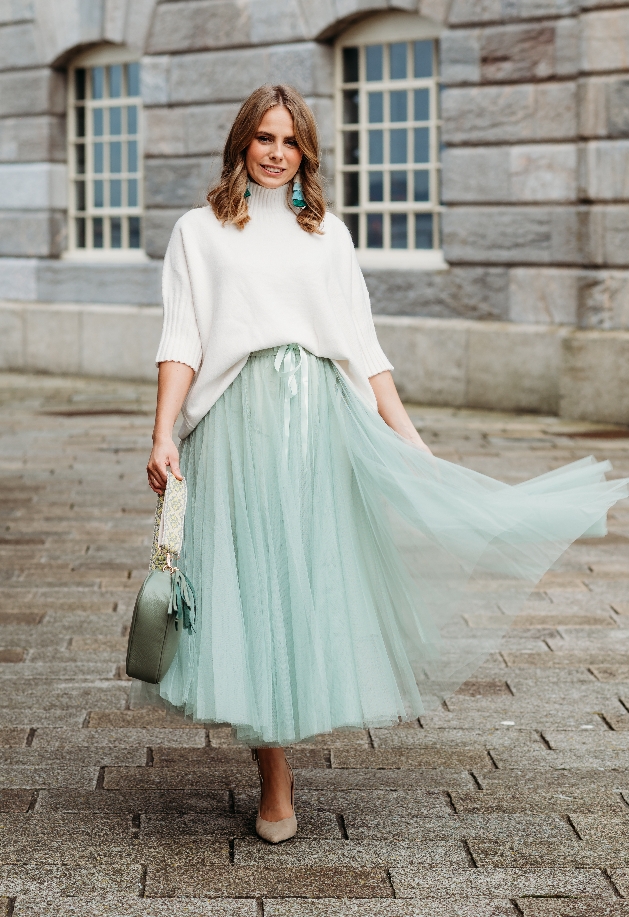 model in cream jumper and mint green tulle skirt