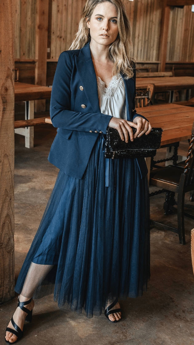 model in blue tulle skirt and blazer standing in a diner