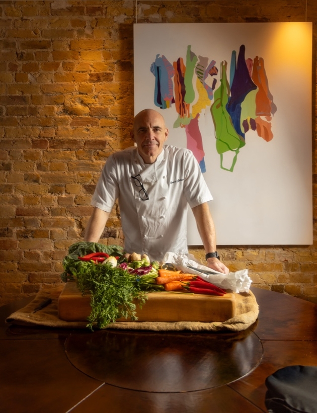 Celebrity chef standing over plate of food
