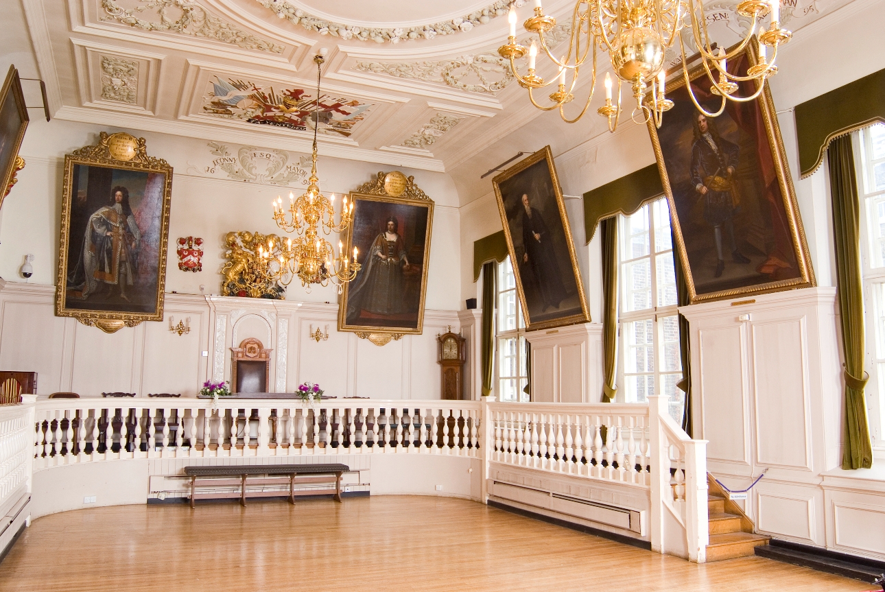 inside historic room with portraits and paintings on the walls
