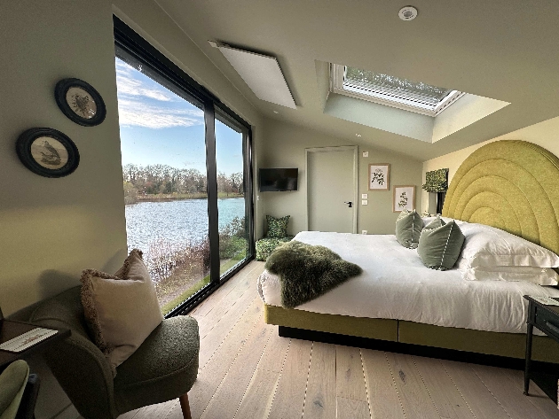 Leeds Castle's new luxury Lakeside Lodges bedroom with large window view of lake
