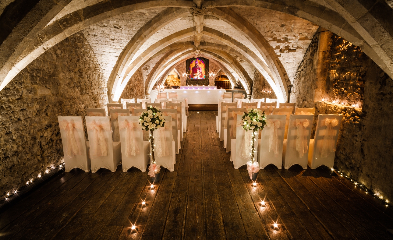 The George Vaults ceremony setting with chair and candles down an aisle