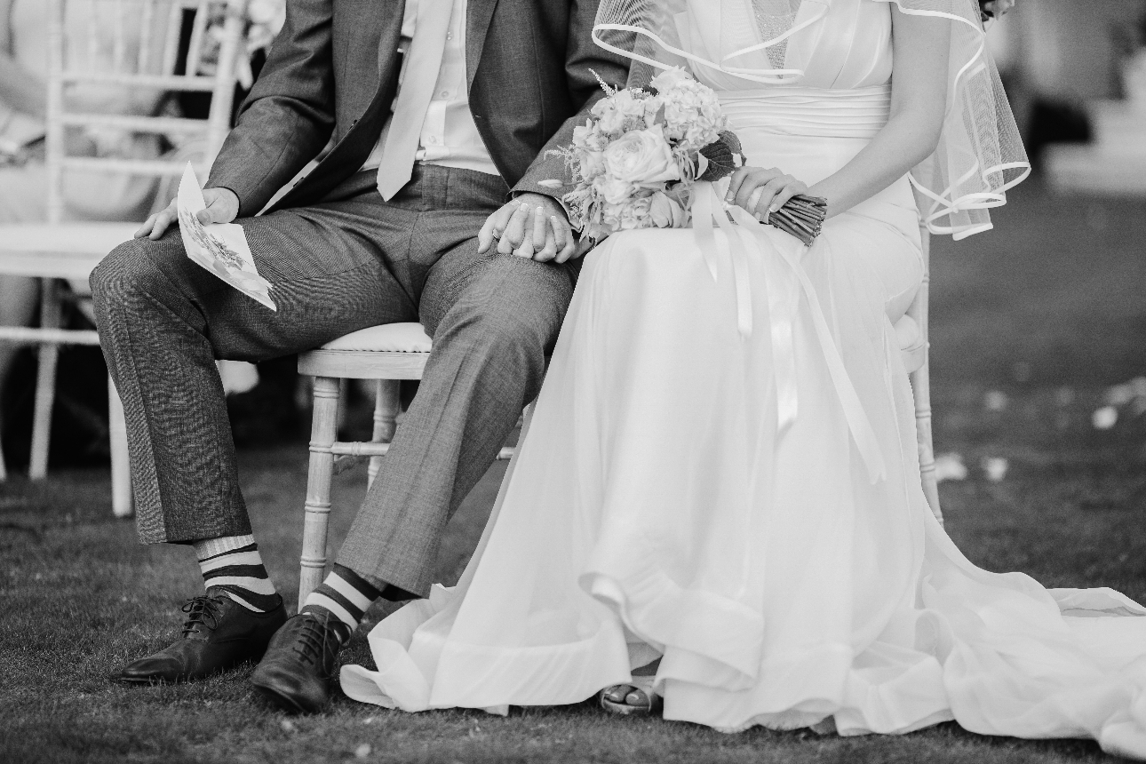 black and white image of a bride and groom holding hands