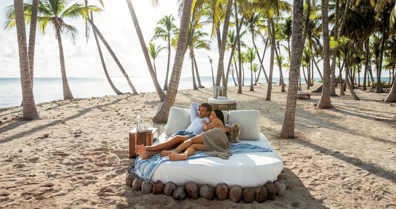 honeymoon couple on a day bed on the beach