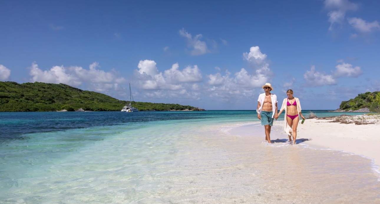 honeymoon couple walking along a tropical beach