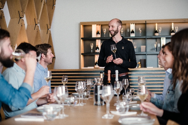 A group of people sitting around a table holding wine glasses