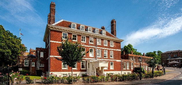 The exterior of a large red brick manor