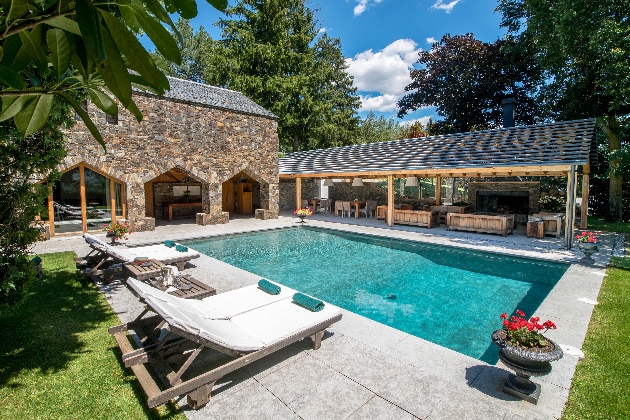 An outdoor swimming pool next to a stone building