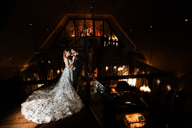 A bride and groom embracing in a dark-lit room
