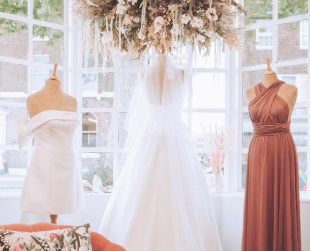 two wedding dresses and one bridesmaid one in shop window