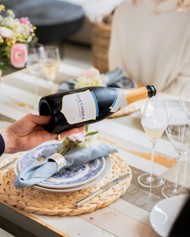 A man pouring a glass of sparkling white wine